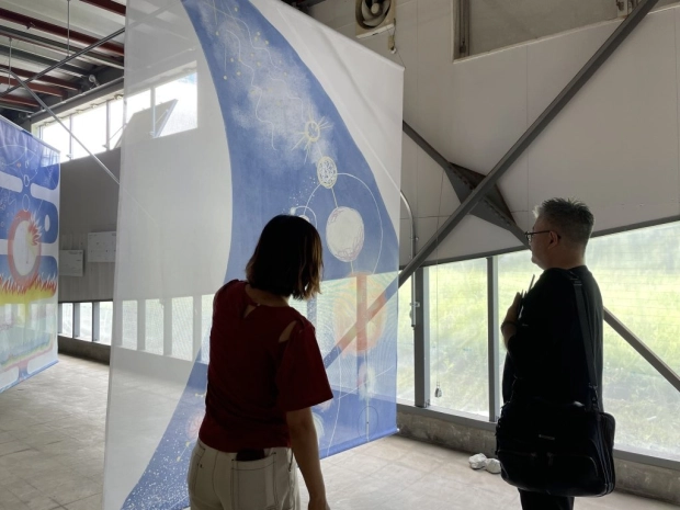 福島県飯舘村にあるアート・カフェ・農業などの複合施設「図図倉庫」（ズットソーコ）を視察する山出さん（右）