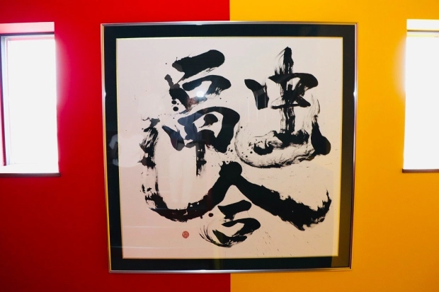 社屋の階段踊り場に飾られた書。書道家が「融合」と揮毫した