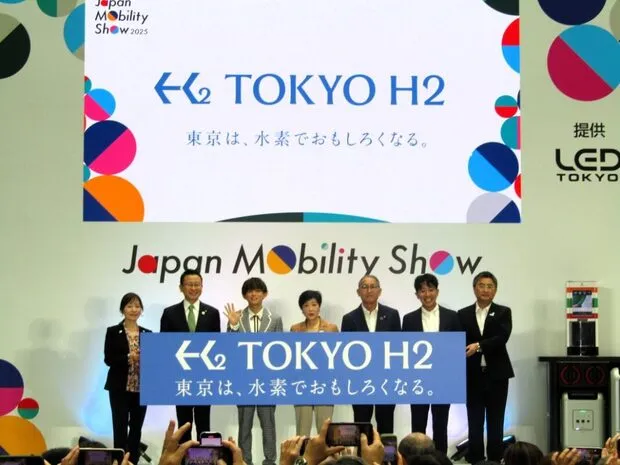 左から松本明子東京都副知事、JR東日本の松本雄一執行役員グループ経営戦略本部経営企画部門長、松丸亮吾さん、小池百合子都知事、SEJの山口繁執行役員、UCCジャパンの里見陵執行役員、トヨタの山形光正水素ファクトリープレジデント