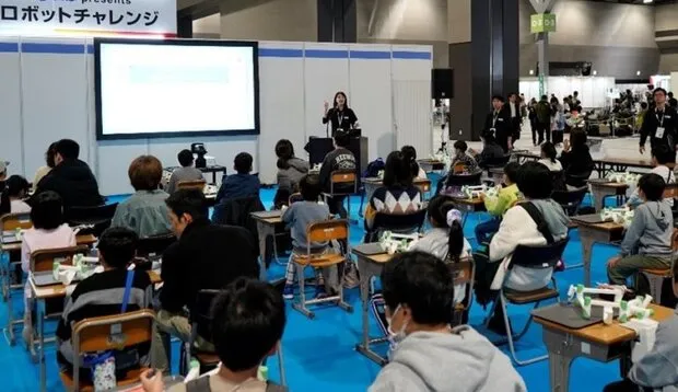 子ども向けにロボットハンドをイメージした装置を使って、箱詰め作業の一部を体験することができる企画も