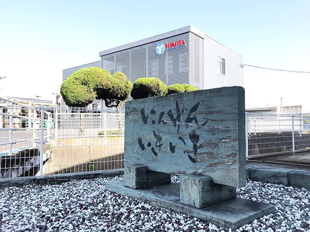 本社の敷地内にある「にんげんいきいき」の文字を刻んだ碑（ヨコタコーポレーション提供）
