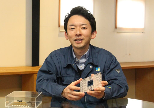 「マイクロ流路チップ」を持ち、海外展開の戦略を語る大場総一郎社長