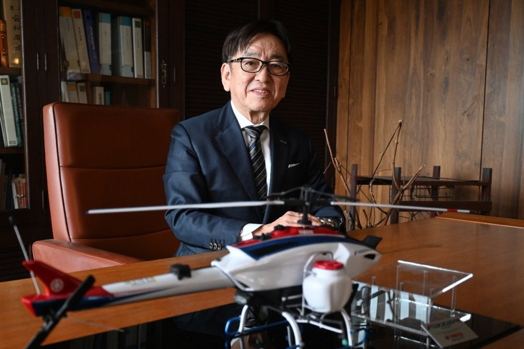 小型無人航空機の模型を前に、DX戦略を語る北浜社長