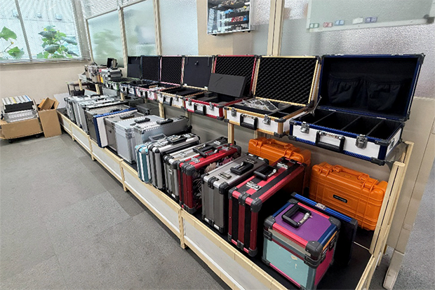 本社の入り口に並ぶ色とりどりのアルミケース