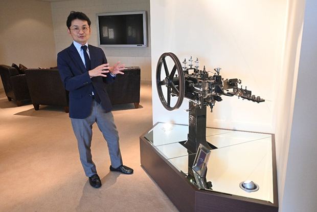 創業当初に内製化した「中空リベット」の製造機械について語る打本社長（福井鋲螺本社で）